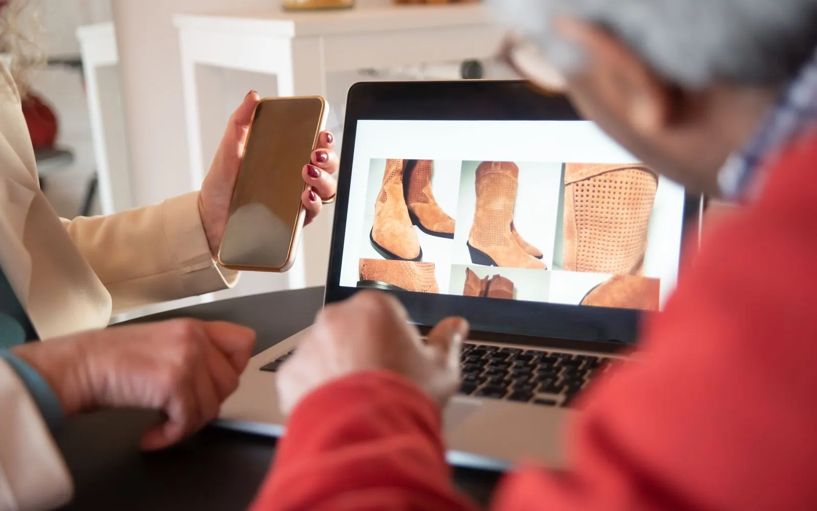 Zwei Personen betrachten einen Onlineshop auf einem Laptop